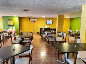 a dining room with tables and chairs and yellow walls at Hotel de Cuautla in Cuautla Morelos