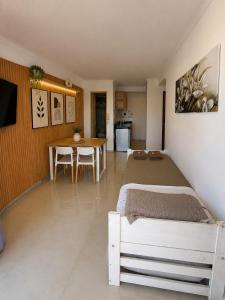 a bedroom with a bed and a table and a kitchen at Suite Premium Vista Panorámica in Santa Teresita +16 photos