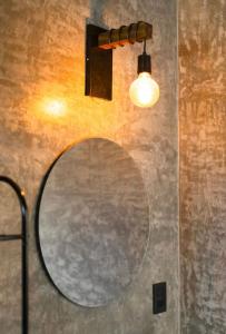 a mirror hanging on a wall with a light at Casa Gulal in Teotitlán del Valle