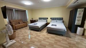 a hotel room with two beds and a couch at omni1818 in Bang Kapi +12 photos