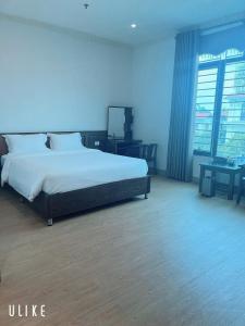a bedroom with a large bed with a blue wall at Khách Sạn VizGoo in Bắc Ninh