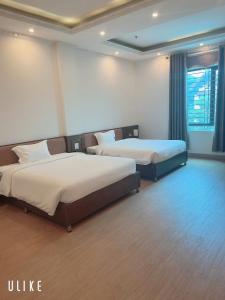 a hotel room with two beds and a window at Khách Sạn VizGoo in Bắc Ninh