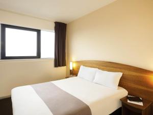 a hotel room with a bed and a window at ibis Hotel Northampton Centre in Northampton
