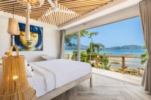 a bedroom with a bed and a large window at Hortensia Luxury Beach Villa in Chaloklum +59 photos