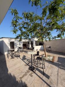 a patio with chairs and tables and a tree at Chalet Escapada in Seville