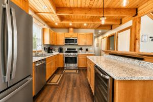 a kitchen with wooden cabinets and stainless steel appliances at Compass Cabin by NW Comfy Cabins in Leavenworth