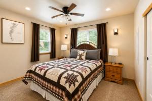 a bedroom with a bed and a ceiling fan at Compass Cabin by NW Comfy Cabins in Leavenworth
