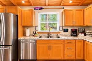 a kitchen with wooden cabinets and a stainless steel refrigerator at Compass Cabin by NW Comfy Cabins in Leavenworth