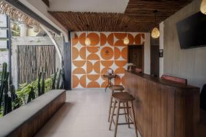 a bar in a restaurant with a large window at Roomates Beach Hostel Canggu by Ini Vie Hospitality in Canggu