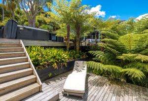 a garden with a bench and trees and plants at Paradise at Palm Beach in Palm Beach
