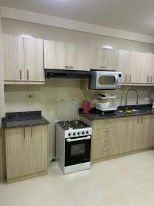 a kitchen with a stove and a microwave at House Mei in Oruro
