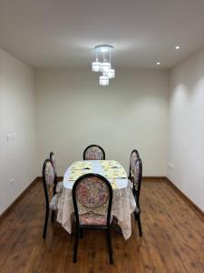 a dining room table with four chairs and a chandelier at House Mei in Oruro +6 photos