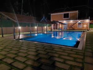 a swimming pool at night with lights on it at Credible Heritage Resort in Varkala