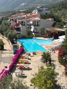 a view of a swimming pool with chairs and tables at Olives Residence in Dhërmi