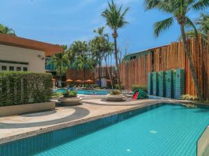 ein Swimmingpool in einem Resort mit Palmen in der Unterkunft OK Phuket in Kata Beach