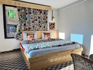 a bedroom with a wooden bed in a room at The AISHANA PAHALGAM in Pahalgām