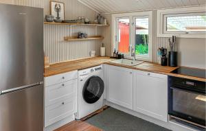a kitchen with white cabinets and a washer and dryer at 2 Bedroom Stunning Home In Vordingborg in Vordingborg