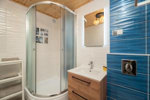 a bathroom with a sink and a shower at Domki Jelonek - Ogrzewane, klimatyzowane, balia-jacuzzi in Władysławowo +38 photos