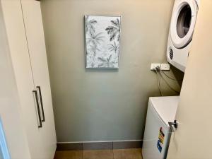 a bathroom with a picture on the wall next to a toilet at Beautiful Brighton in Melbourne