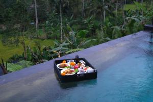 a tray of food on a raft in the water at The Ruler Bali in Penginyahan