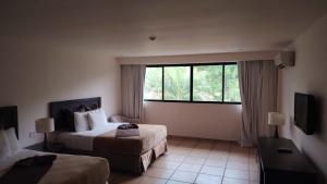 a hotel room with two beds and a window at Private family room in Coronado Luxury Club & Suites in Playa Coronado