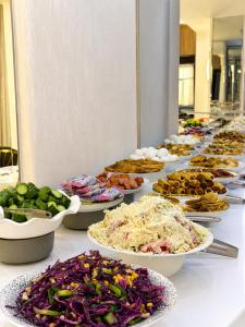 a buffet line of plates of food on a table at Firdavsi Hotel in Dushanbe