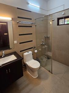 a bathroom with a toilet and a sink and a shower at Mannath Ayur Island Resort in Murinjupuzha +25 photos