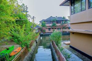 a river in a city with a house and a building at Mannath Ayur Island Resort in Murinjupuzha