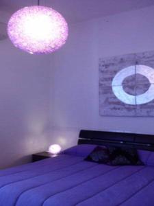 a bedroom with a purple bed and a chandelier at Magic Stefy's Rooms in Rome