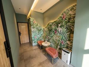 a hallway with a table and chairs and a wall at 會呼吸的房-採自助式入住-有電梯 in Huwei