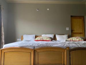 a large wooden bed with two pillows on it at Tsogstot residency in Deskit