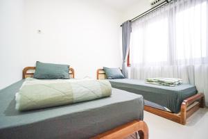 two twin beds in a room with a window at Awana Town House 40 in Timuran