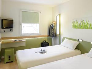a hotel room with two beds and a tv at ibis budget Hotel Brussels Airport in Diegem +60 photos