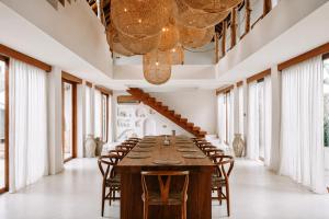 a long dining room with a long table and chairs at Belajar Bali Boutique Hotel and Retreat in Canggu