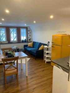 a living room with a blue couch and a table at Ferienwohnungen Berghaus - 2 komfortable Appartements für bis zu 7 Personen in Schmallenberg
