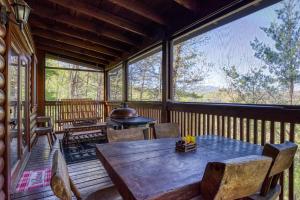 a screened in porch with a wooden table and chairs at Barefoot Dreams in Sevierville