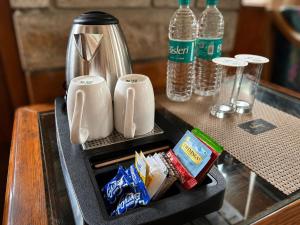 a tray with a coffee maker and drinks on a table at Enroot Manali in Vashisht +12 photos