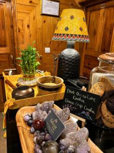 a table with a lamp and a plate of cookies at Enroot Manali in Vashisht