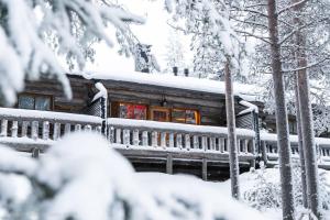 a log cabin covered in snow in the woods at Kelo Haven, 2 x skipasses Ruka-Pyhä included, skibus nearby in Ruka