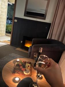 a person holding a glass of wine and a plate of food at All Seasons Mansfield in Mansfield