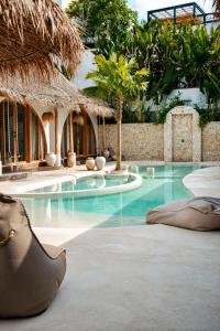 a swimming pool with blue water in a resort at Belajar Bali Boutique Hotel and Retreat in Canggu