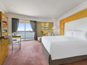 a hotel room with a large bed and a balcony at Sofitel Cairo Nile El Gezirah in Cairo