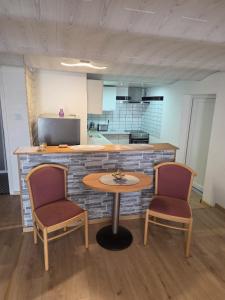 Eine Küche mit einem Tisch, zwei Stühlen und einer Theke in der Unterkunft Panoramic Hause in Uttenweiler + 3 Fotos
