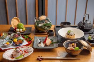 a wooden table with plates of food on it at KAMAKURA Hotel in Kamakura