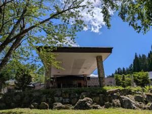 a house on top of a hill with trees at WHITE HOTEL GRAND HAKUBA in Omachi
