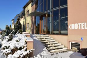 un bâtiment avec de la neige sur les escaliers en face de celui-ci dans l'établissement Motel Paradise, à Torzym