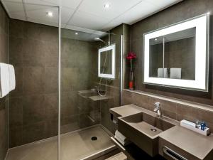 ein Badezimmer mit Waschbecken und Dusche in der Unterkunft Novotel The Hague World Forum in Den Haag + 29 Fotos