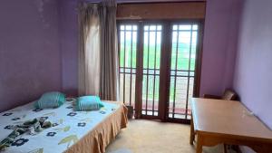 a bedroom with a bed and a table and a window at Iris Grand Hotel in Nittambuwa