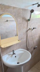 a bathroom with a sink and a mirror at Iris Grand Hotel in Nittambuwa