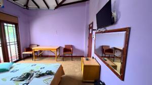 a room with a bed and a mirror and a table at Iris Grand Hotel in Nittambuwa